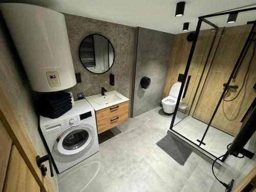 y baño con lavadora y lavamanos. en Gray Apartment 24h - Parking, en Katowice