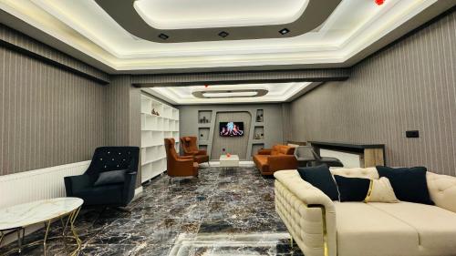 eine Lobby mit einem Sofa und Stühlen sowie einem TV in der Unterkunft El Baboos Hotel in Bostaniçi