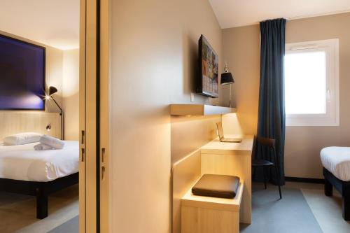 Cette chambre comprend un lit, un bureau et un lit. dans l'établissement ibis Douai Dechy, à Dechy