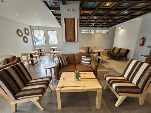 uma sala de espera com sofás, mesas e cadeiras em CASA CRISTOBAL Centenario em Cusco