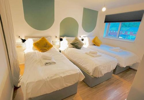 duas camas num quarto com dois gatos sentados sobre elas em 20% Monthly stays - 3 bedrooms @ Homevy Leeds em Beeston Hill