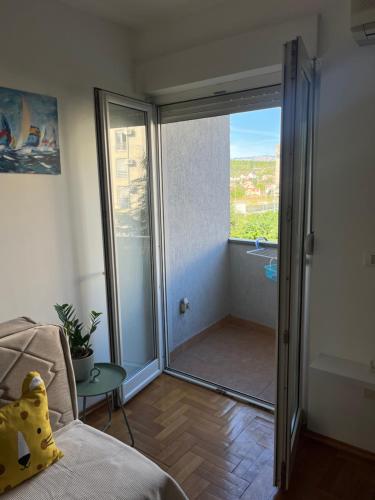 a living room with a sliding glass door to a balcony at Studio 6 in Podgorica