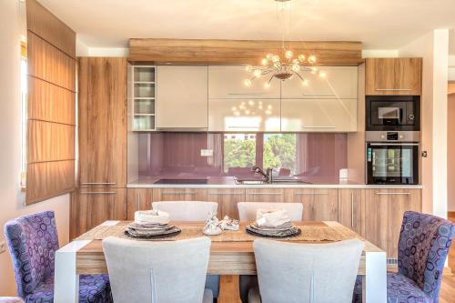 a kitchen with a wooden table and chairs at VIP Apartments in Sarajevo