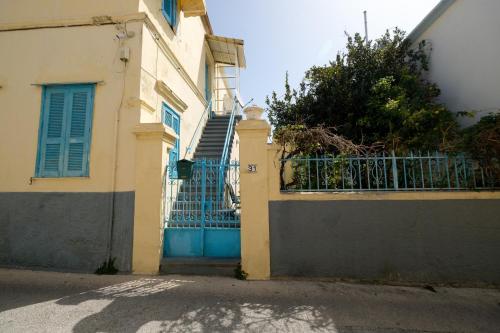 a building with a blue gate and a fence at Archontiko Pataka in Rhodes Town