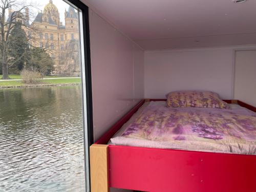 uma cama num quarto ao lado de uma janela com água em COSY Explorer - führerscheinfrei em Schwerin