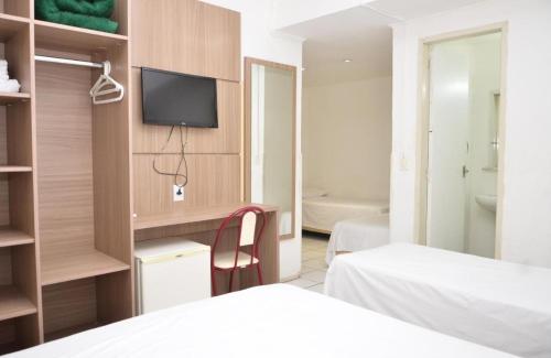 um quarto de hotel com duas camas e uma televisão em Hotel Manoá Poa em Porto Alegre