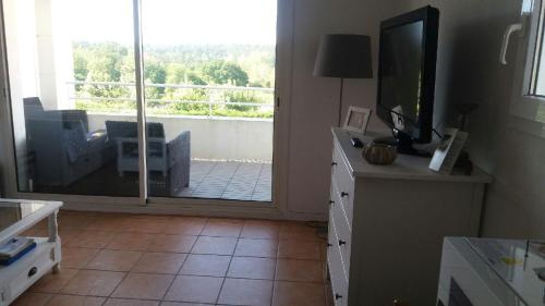 d'un salon avec une télévision et une porte coulissante en verre. dans l'établissement studio la colline bleue, à Biarritz