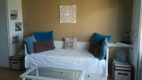 une chambre avec un lit avec des oreillers bleus dans l'établissement studio la colline bleue, à Biarritz