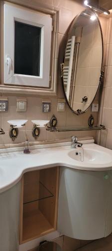 een badkamer met een wastafel en een spiegel bij L'ARRA DE LA ROSERAIE in Bonnebosq