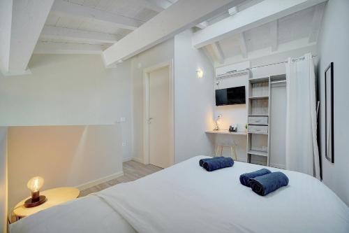 - une chambre blanche avec 2 oreillers bleus sur un lit dans l'établissement Le Paco - 600 m plage - Verrière Côte d'Azur, à Cannes