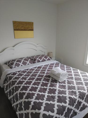 una camera da letto con un letto con un piumone bianco e nero di Zion inn economy 2 a Saint John