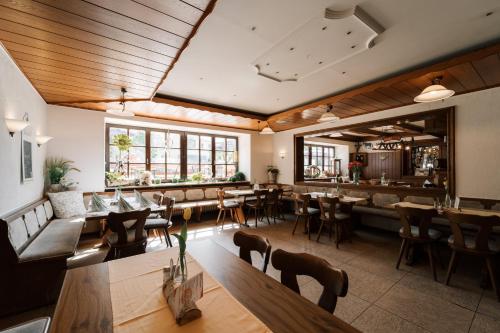 un restaurante con techos de madera, mesas y sillas en Hotel Weisses Ross, en Konnersreuth