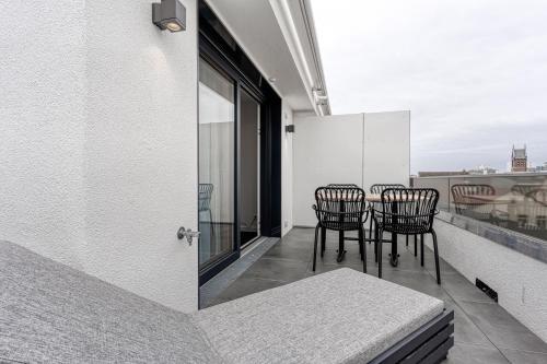 a balcony with chairs and a table on a building at Haus Noena in Norderney