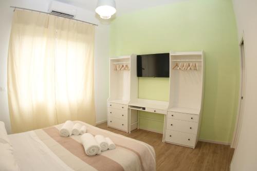 Schlafzimmer mit einem TV und einem Bett mit Handtüchern in der Unterkunft LUCKY LOFT 16 in La Spezia