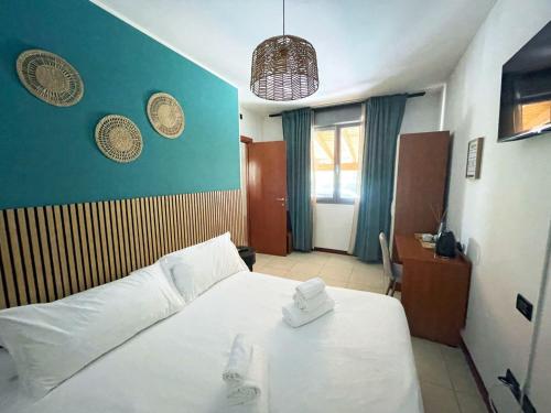 a bedroom with a white bed and a blue wall at Doge Veneziano in Mestre