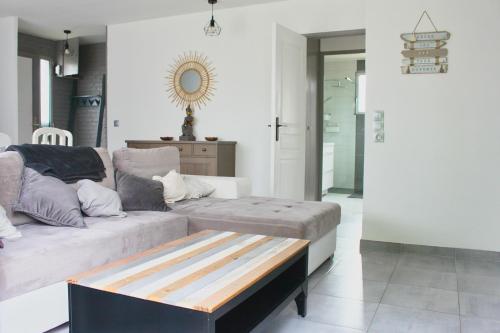 a living room with a couch and a coffee table at Bienvenue ! Maison chaleureuse à 7 min. des plages in Saint-Lormel