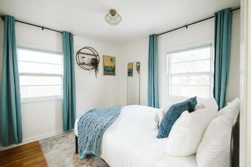 Schlafzimmer mit einem weißen Bett und blauen Vorhängen in der Unterkunft Incredible Loc! Fast Wifi Parking Fire Pit in Boise