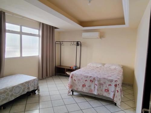um quarto com 2 camas e uma janela em APtº 1º andar em Olinda Casa Caiada a 100 mts da praia em Olinda