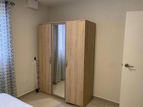 a wooden cabinet in a bedroom with a mirror at Blue Lagun Apartment B in Willemstad