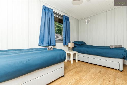 1 dormitorio con 2 camas y ventana en Firbush Lochside Lodges en Killin