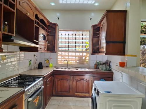 a kitchen with wooden cabinets and a stove top oven at Jardin de Fann in Dakar
