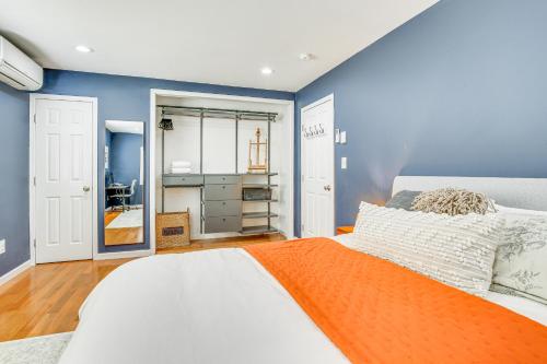 a bedroom with a large bed with an orange blanket at Pet-Friendly Hopewell Junction Home with Pool in Hopewell Junction