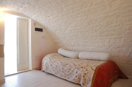 ein Schlafzimmer mit einem Bett und einer Wand in der Unterkunft Casa Mario in Cisternino