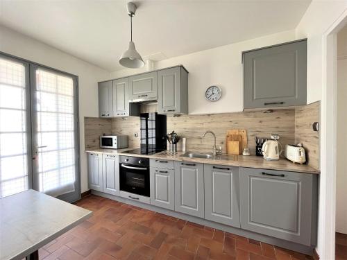 une cuisine avec des armoires blanches et un évier dans l'établissement la Petite Seibel, à Les Bussolleries