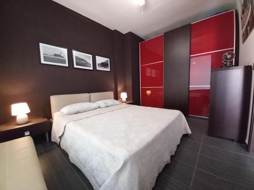 a bedroom with a white bed and red cabinets at casamares in Isola delle Femmine