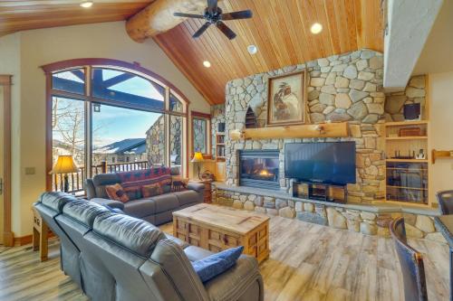 a living room with a fireplace and a stone wall at Spacious Whitefish Home with Sauna and Ski Resort View in Whitefish