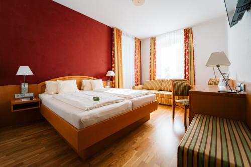 pokój hotelowy z łóżkiem i kanapą w obiekcie Hotel Weisses Ross w mieście Konnersreuth