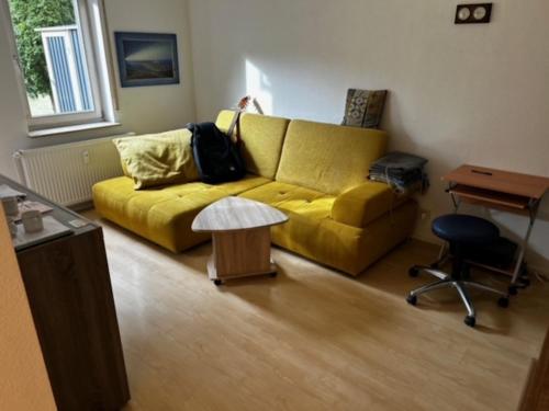 a living room with a yellow couch and a table at La Luna in Beuren