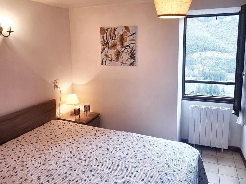 a bedroom with a bed and a window at Maison pittoresque à Mostuéjouls avec vue sur la montagne in Mostuéjouls