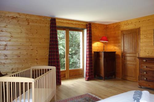 Zimmer mit Kinderbett und Fenster in einer Hütte in der Unterkunft Grand gite de la Bourrélie in Plazac