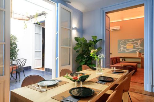 un comedor con mesa y sillas y una habitación con en Maison Belmonte - Suites in Palermo en Palermo