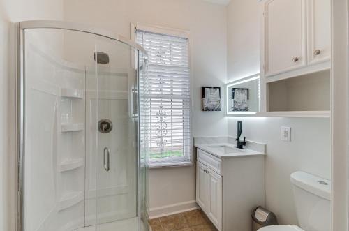 baño blanco con ducha y lavamanos en Stylish Home about 2 Mi to Jackson State and Belhaven! en Jackson