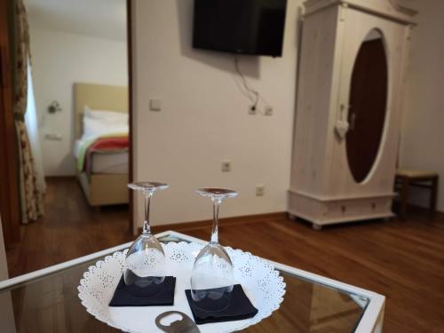 a table with two wine glasses on top of it at Room in Guest room - Pension Forelle - Suite in Forbach