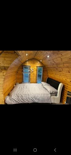 a bedroom with a bed and a chair in a room at New hotub glamping pods in Kinlet