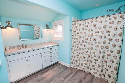 a bathroom with a shower curtain and a sink at NH300, Driftwood Dreams- Oceanside, Near shopping, Close to Ocean! in Nags Head