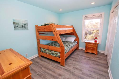 a bedroom with a wooden bunk bed with a window at NH300, Driftwood Dreams- Oceanside, Near shopping, Close to Ocean! in Nags Head