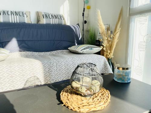 une chambre avec un lit et une cage pour oiseaux sur une table dans l'établissement L Oyat, à Saint-Gilles-Croix-de-Vie