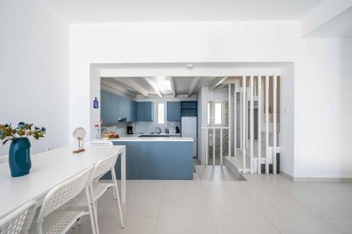 a kitchen with blue cabinets and a table and chairs at Villa Xenos Ciel in Tigaki