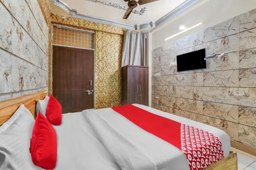 ChinhatにあるFlagship Hotel Sai Palace Near Gomti Riverfront Parkのベッドルーム(赤い枕のベッド1台、テレビ付)