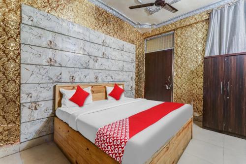 - une chambre avec un lit et des oreillers rouges dans l'établissement Flagship Hotel Sai Palace Near Gomti Riverfront Park, à Chinhat
