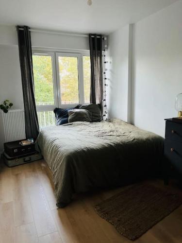 une chambre avec un grand lit et une fenêtre dans l'établissement Nid ensoleillé & vue Seine, à Villeneuve-la-Garenne