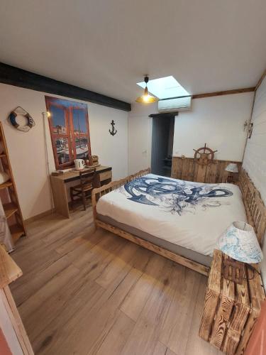 a bedroom with a large bed and a desk at DOMAINE DE LA LUCARLIERE in Saint-Cyr-des-Gâts