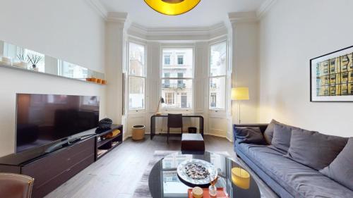 - un salon avec un canapé et une télévision dans l'établissement Notting Hill 1 bedroom flat, à Londres