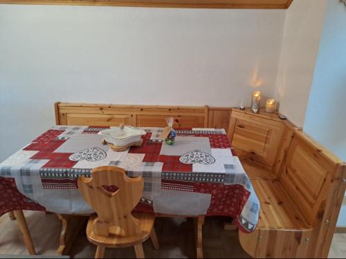 a dining room table with a red and white quilt on it at Cèsa Pier Sellaronda Dolomiti in Campitello di Fassa