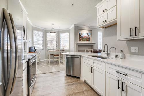 a kitchen with white cabinets and stainless steel appliances at Near Spring Training Mesa Condo with Pool Access! in Mesa