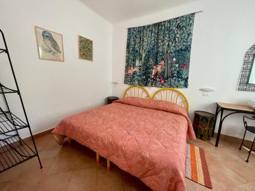 een slaapkamer met een bed met een oranje sprei bij Agriturismo La Realidad in Finale Ligure